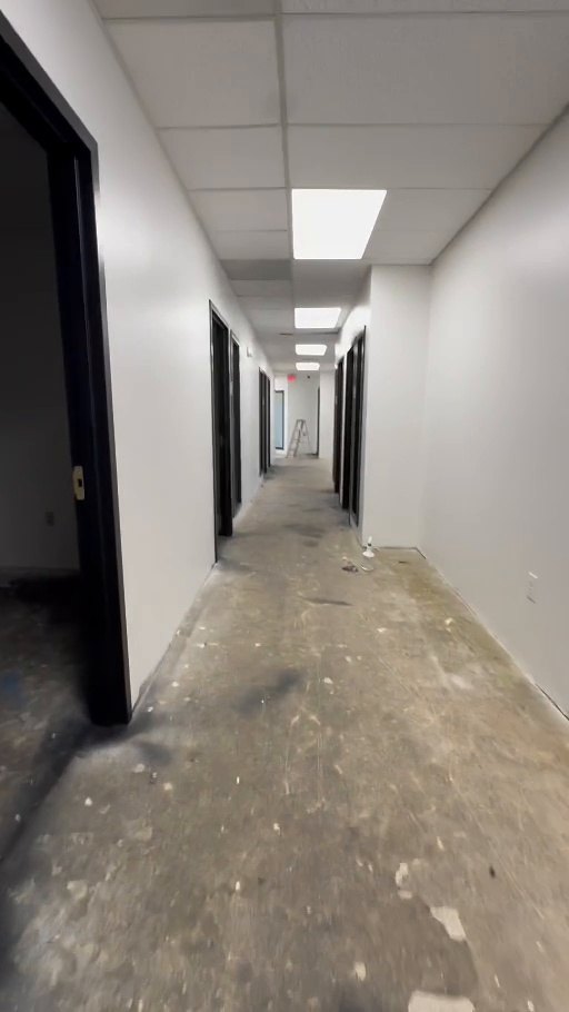 Commercial corridor with finished painted walls and dark door frames