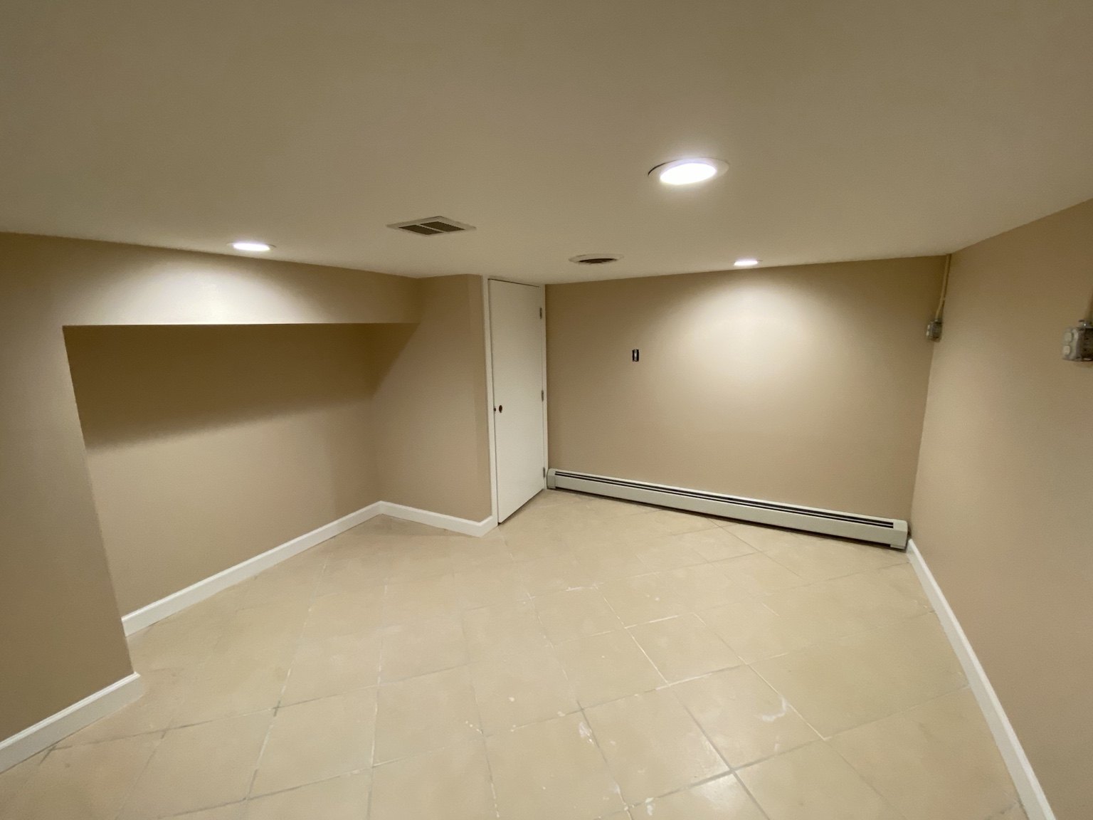 Finished lower-level room with fresh paint and white trim