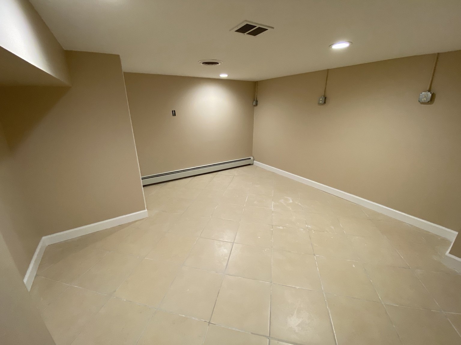 Finished lower-level room with painted walls and bright white trim