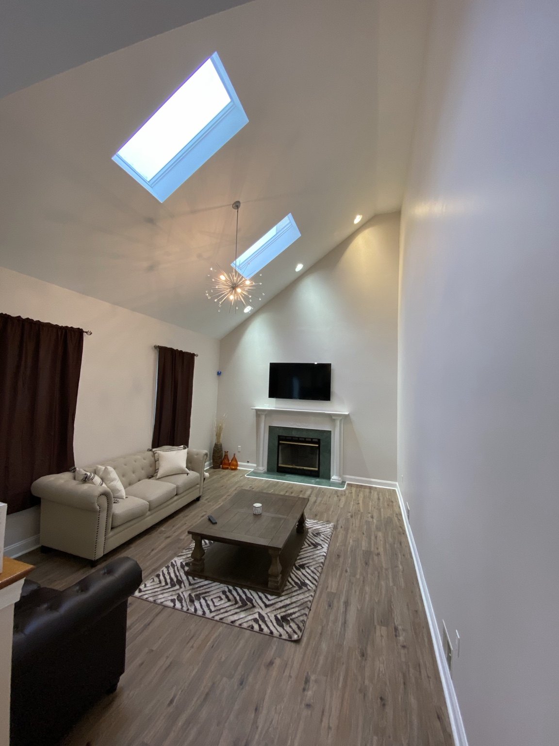 Finished high-ceiling living room with skylights and painted surfaces